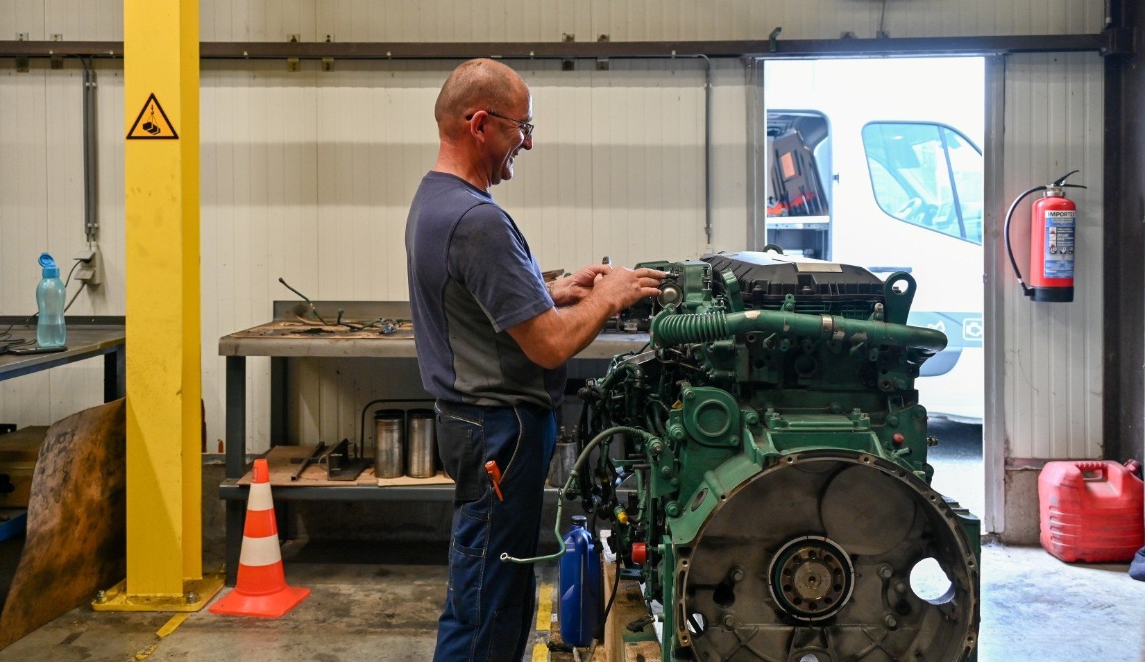 Technicus werkt aan een motor in de werkplaats van Derma Trucks.