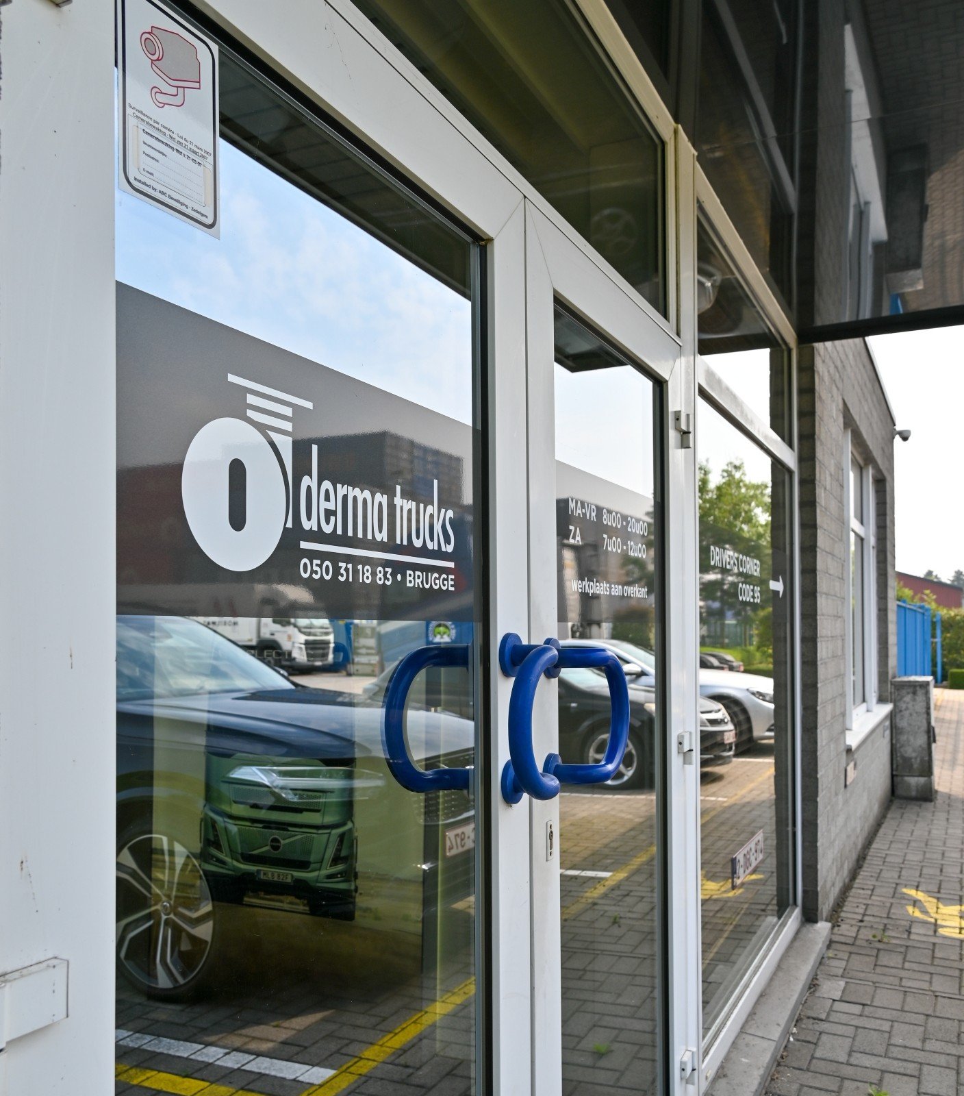 Glazen voordeur met logo van Derma Trucks.